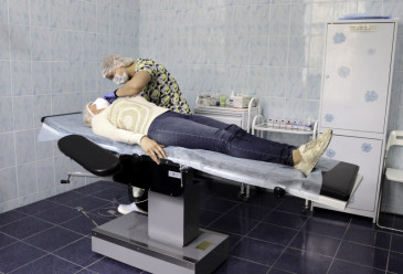 Пациентка на кушетке и врач во время процедуры